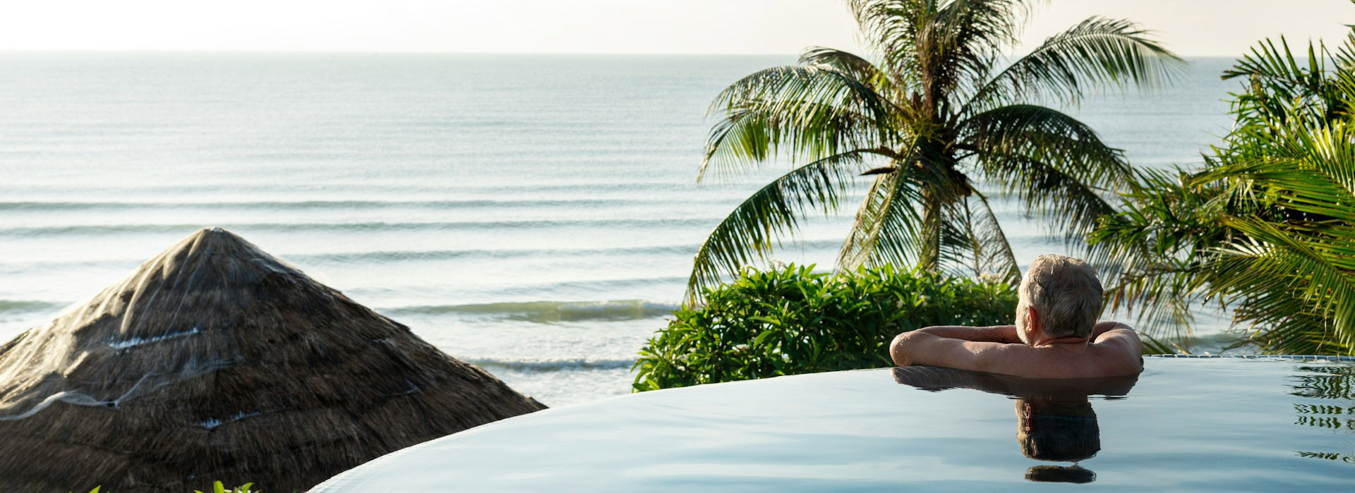 Guest relaxing in an infinity pool overlooking the ocean